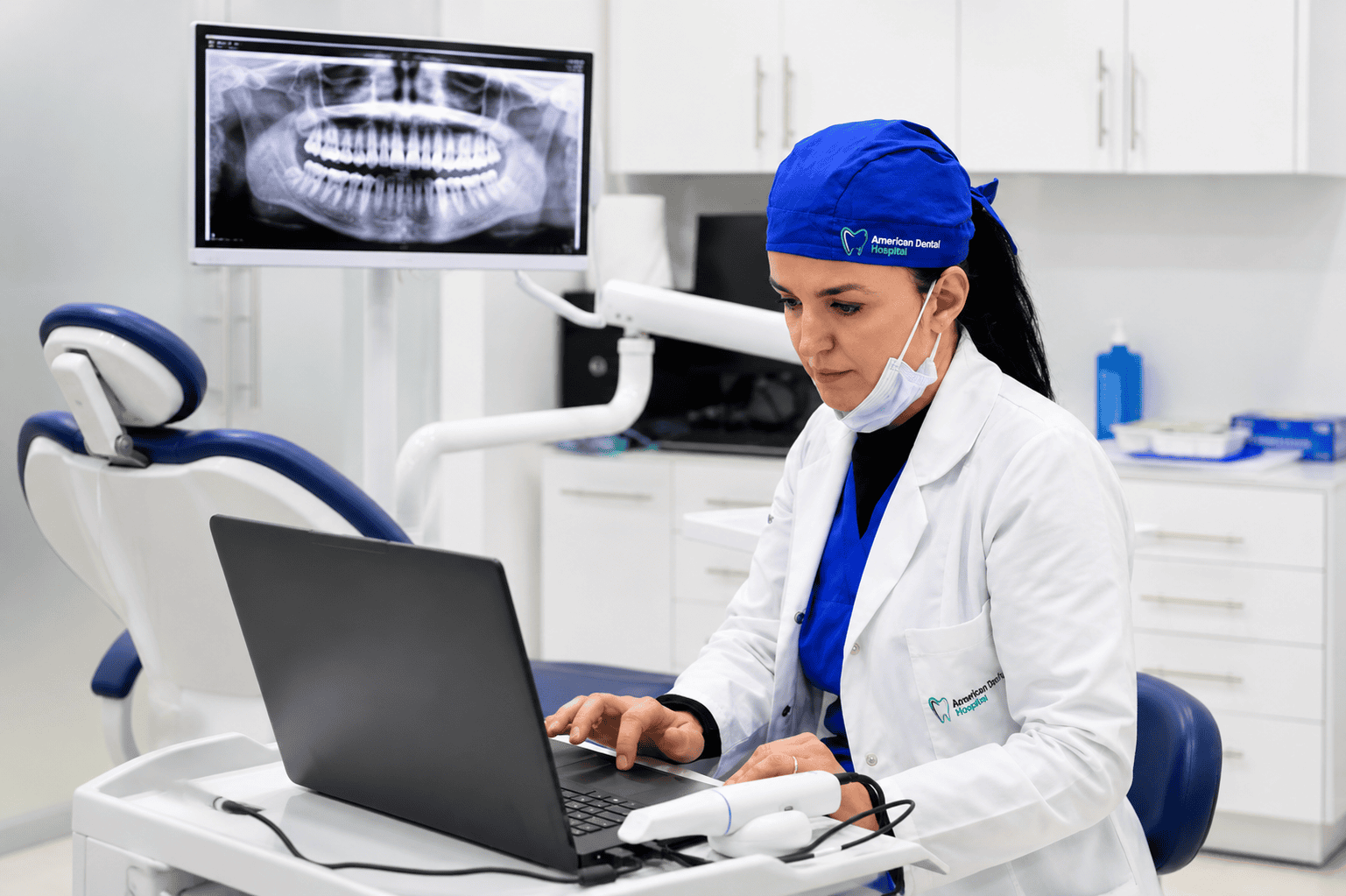 Dentista che analizza una radiografia dentale al computer in uno studio dentistico.