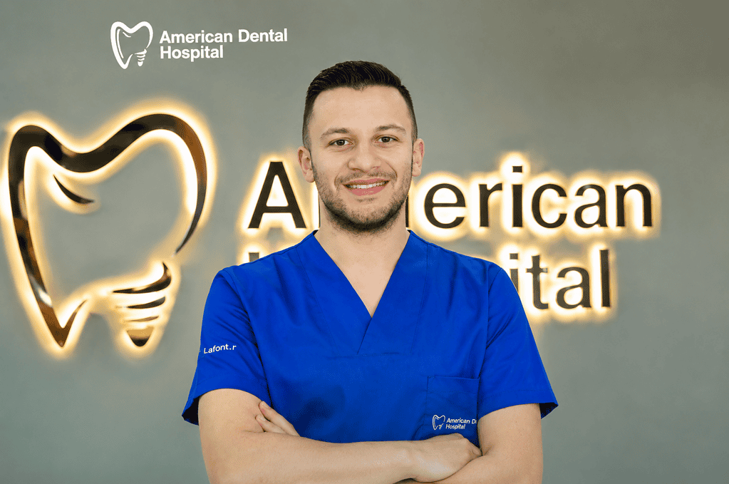 Dental professional in blue scrubs at American Dental Hospital with logo.