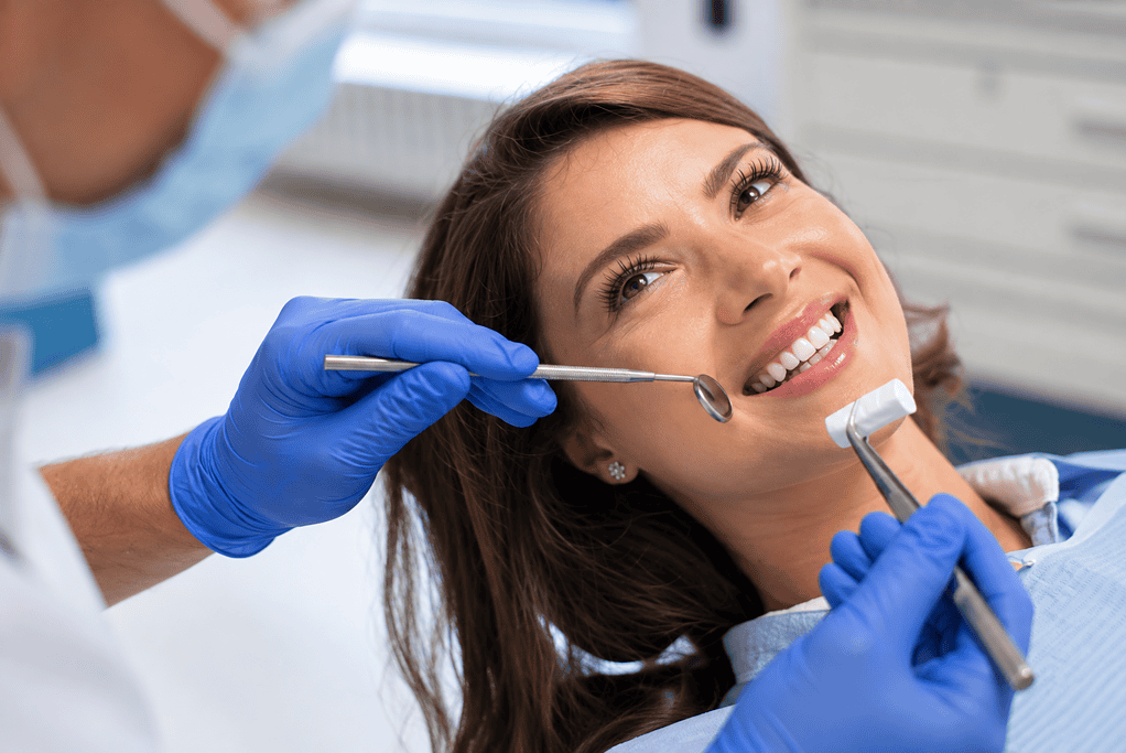 Woman receiving dental checkup from dentist in clinic.