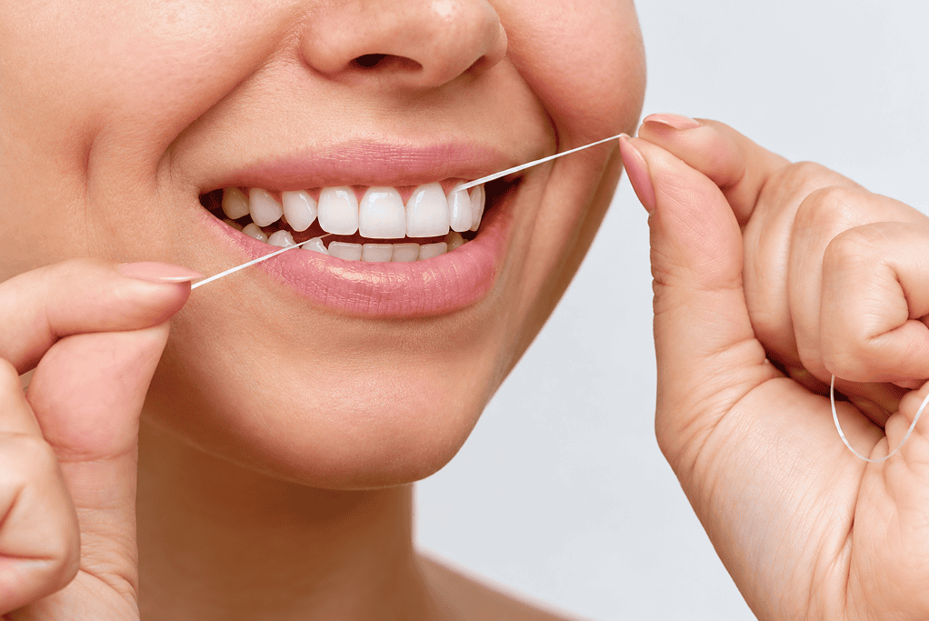 Person flossing teeth to promote oral hygiene and healthy smile.