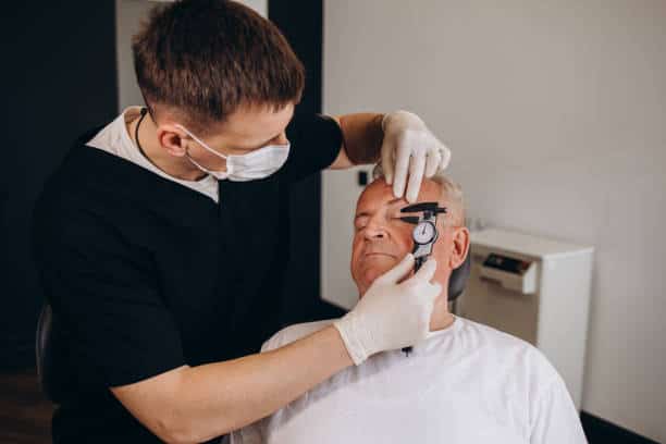 An elderly man at an appointment with a plastic surgeon in Albania for blepharoplasty.