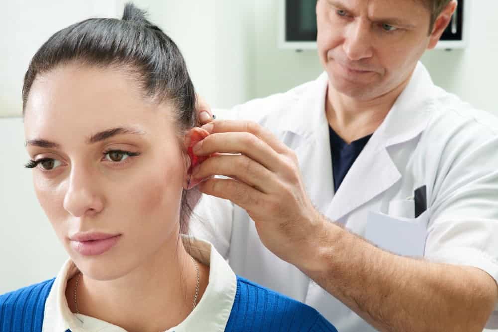 Doktor duke kryer otoplastikë te një grua në një klinikë mjekësore në Shqipëri.
