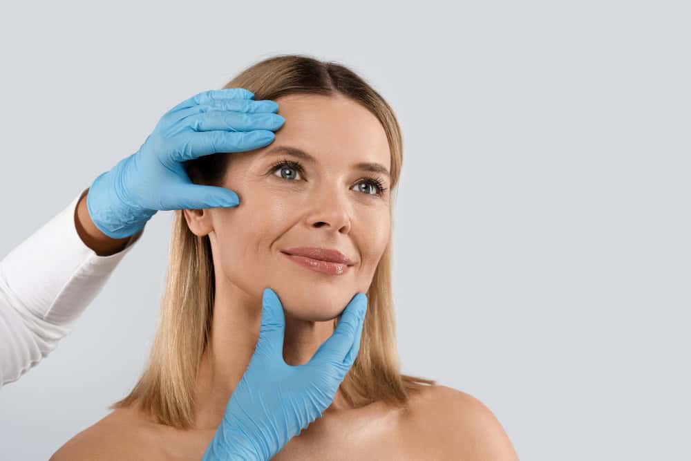 Woman receiving a facial assessment for cosmetic surgery in Albania.